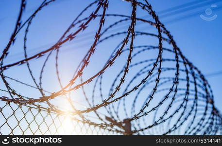 Fence with a barbed wire under a blue sky