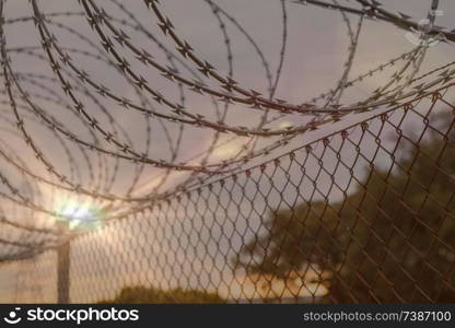 Fence with a barbed wire under a blue sky