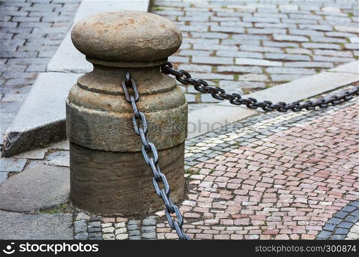 fencing of sidewalk in form of posts with iron chains