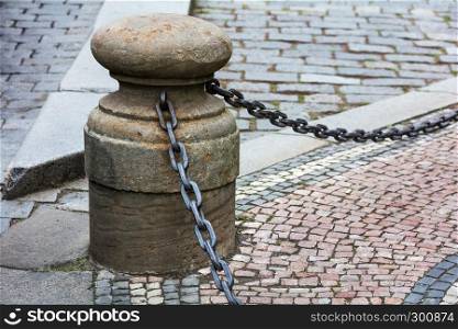 fencing of sidewalk in form of posts with iron chains