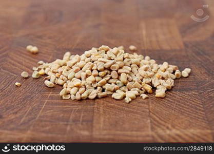 Fenugreek seeds on a brown surface