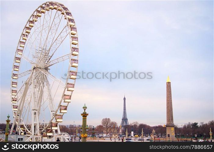 Ferries wheel in Paris at dusk. Eiffel Tower on the background.