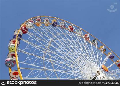 Ferris wheel in an amusement park against blue sky. Ferris wheel in an amusement park