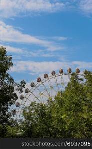 Ferris wheel in an amusement park in a green region