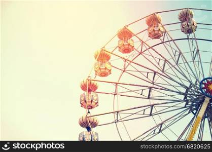 Ferris wheel on sky background with sunlight retro effect image