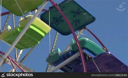 Ferris wheel with multicolored cabins in amusement park