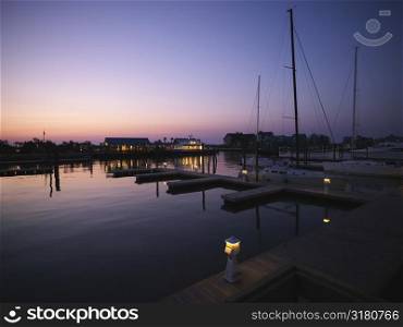 Ferry boat and sail boats at marina at dusk at Bald Head Island, North Carolina.