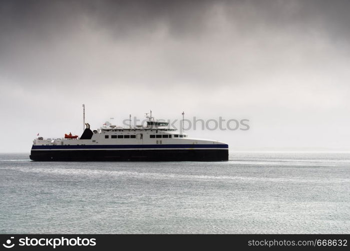 Ferry boat on water fjord, cloudy rainy weather, Lofoten Norway. Travel and tourism.. Fjord with ferry boat, Norway.