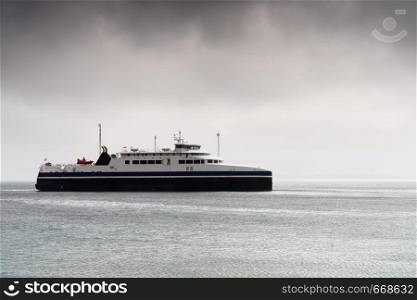 Ferry boat on water fjord, cloudy rainy weather, Lofoten Norway. Travel and tourism.. Fjord with ferry boat, Norway.