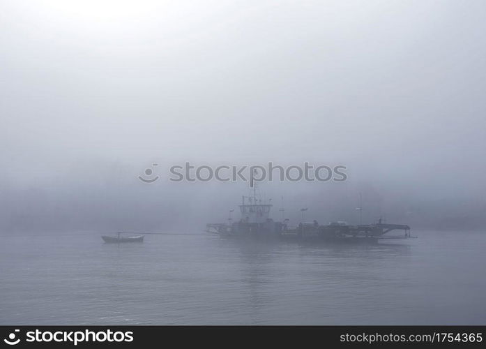 ferry in the mist on river lek near culemborg and utrecht in the netherlands