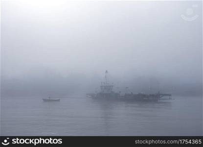 ferry in the mist on river lek near culemborg and utrecht in the netherlands