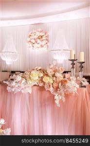 festival wedding table decoration with crystal chandeliers, golden candlestick, candles and white pink flowers and pink cloth. stylish wedding day.. festival wedding table decoration with crystal chandeliers, golden candlestick, candles and white pink flowers and pink cloth. stylish wedding day