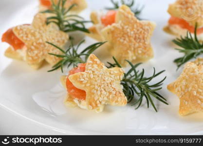 Festive appetizer of puff pastry in the shape of a star, stuffed with salmon and soft cheese. The perfect appetizer for your holiday table.