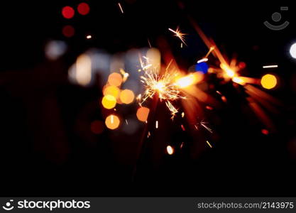 Festive background, bengal light on the dark background, New Year with sparklers sparks on a festive background. selective focus. Festive background, bengal light on the dark background, New Year with sparklers sparks on a festive background. selective focus.