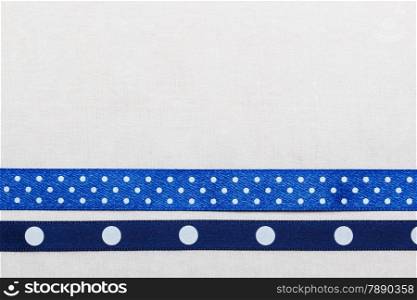 Festive celebration party frame. Polka dot navy blue satin ribbon on white cloth background
