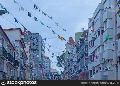 festive city street with decoration of the flags in evening time