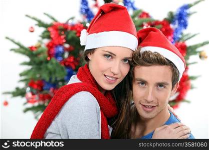 Festive couple in front of Christmas tree
