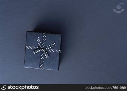 Festive flat lay scene with gift box in minimal black color. Festive flat lay scene with gift box