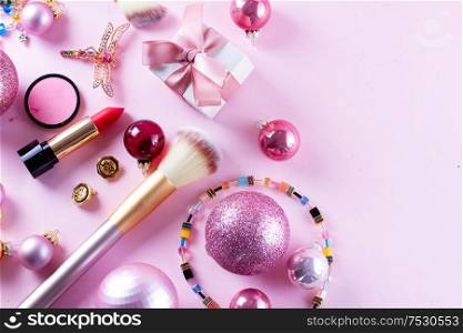 Festive make up products on pink background, top view border with copy space. Festive make up
