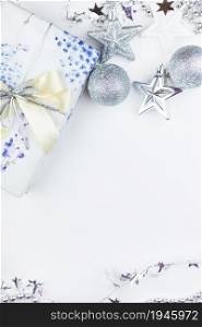 Festive mood, preparation for the holiday. Christmas gift box with festive decor in silvery colors - toys, star, round balls. Festive mood, preparation for the holiday. Christmas gift box with festive decor in silvery colors - toys, star, round balls.