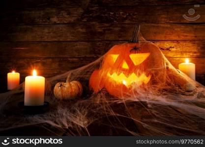 Festive mystical halloween interior. Pumpkin, spider web, burning candles, spiders on dark wooden background. Festive mystical halloween pumpkins