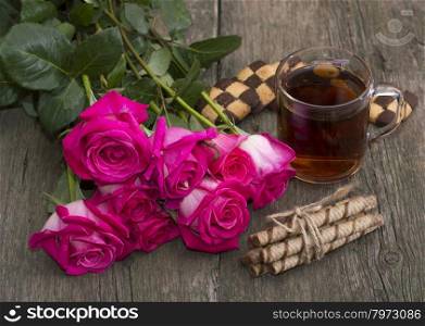 festive still life from flowers, cookies and tea on a wooden table
