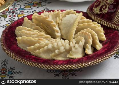 Festive tagine with traditional Gazelle Horns cookies on the table with embroidered table cloth