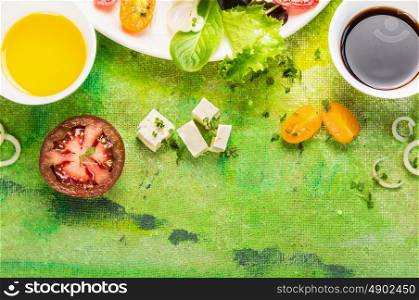 feta cheese salad with tomatoes, oil and vinegar dressing on green background, top view, frame