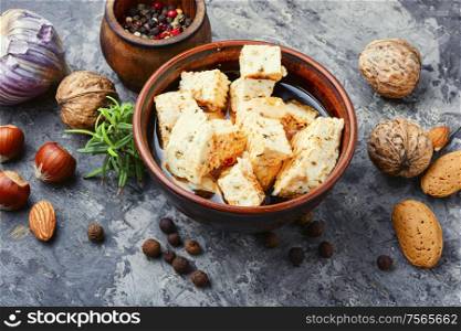 Feta cheese with spice and garlic in bowl. Homemade feta cheese with herbs