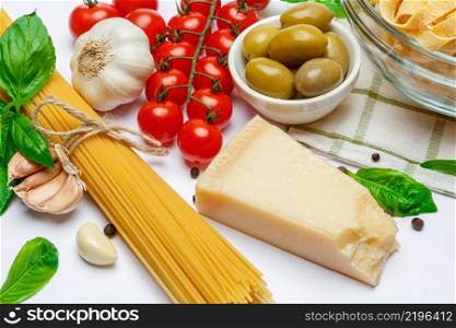 Fettuccine and spaghetti, vegetables with ingredients for cooking pasta isolated on a white background, top view. Flat layout. Fettuccine and spaghetti, vegetables with ingredients for cooking pasta