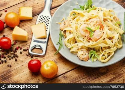 Fettuccini pasta with shrimp on wooden table.Italian food. Plate of pasta with shrimps