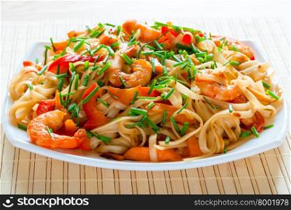 fettuccini with shrimp, vegetables and spicy sauce closeup