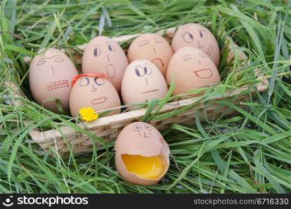 few deorated eggs in a basket on grass