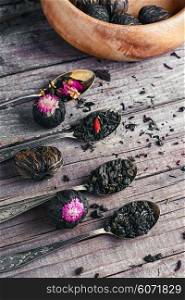 Few flavors of dry brewing loose leaf tea on wooden table. Varieties of loose leaf tea
