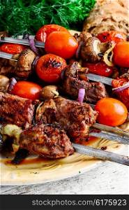 few of the skewers with cooked meats and fried tomatoes. Beef on skewers