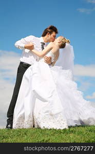 fiance kisses bride on to the meadow