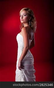 Fiancee - beautiful blonde wedding model in bridal white dress standing on podium