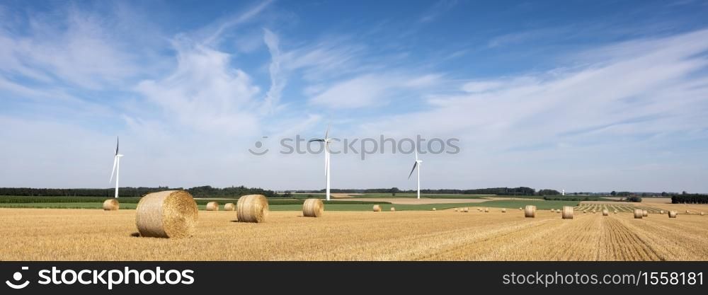 fields and wind turbine in french part nord pas de calais under blue sky in summer