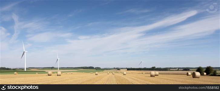 fields and wind turbines in french part nord pas de calais under blue sky in summer