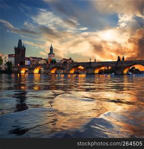 Fiery sunset over Charles bridge on river Vltava in Prague