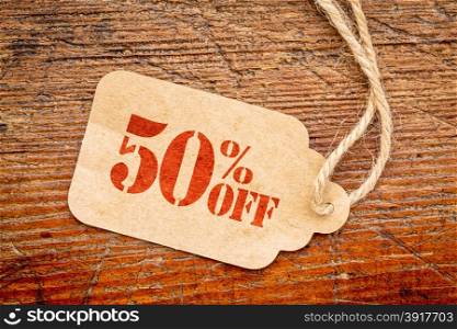 fifty percent off discount - a paper price tag against rustic red painted barn wood