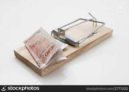 fifty pound note set on a mousetrap on white background