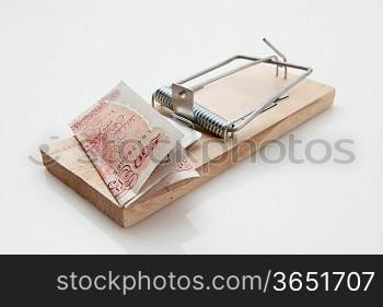 fifty pound note set on a mousetrap on white background