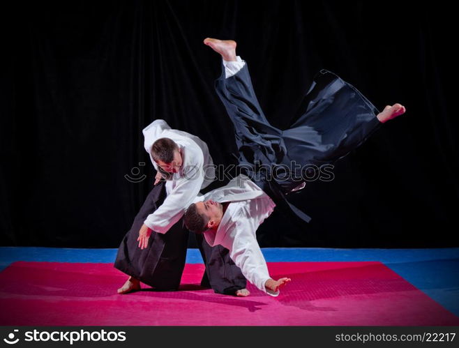 Fight between two aikido fighters on black