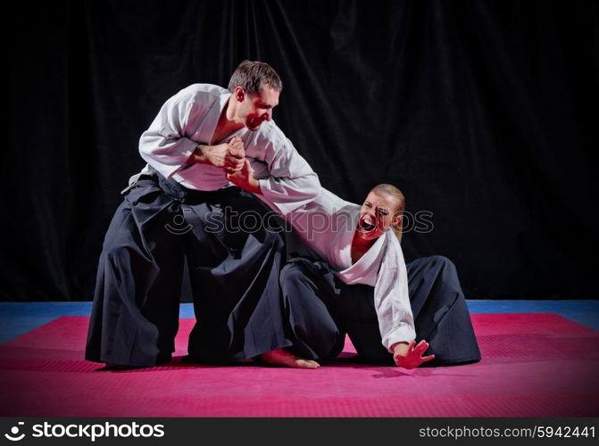 Fight between two aikido fighters on black