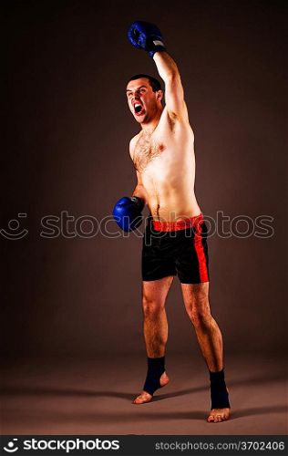 fighter with hands up on gray background