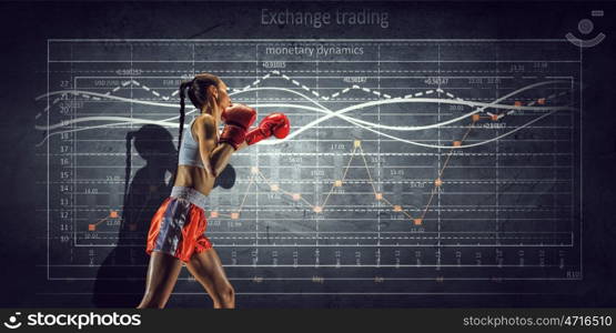 Fighting for sales dynamics. Boxer woman over dark background with graphs and diagrams