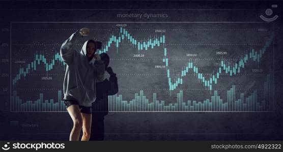 Fighting for sales dynamics. Boxer woman over dark background with graphs and diagrams