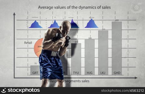 Fighting for sales dynamics. Muscular boxer man over dark background with graphs and diagrams