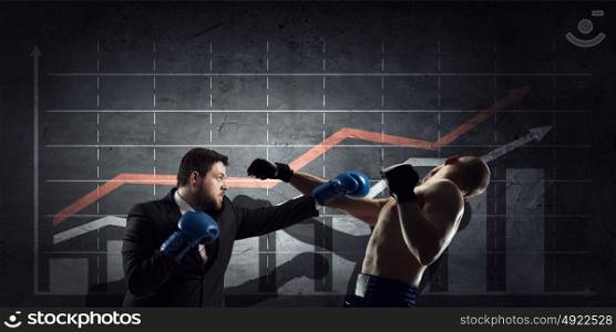 Fighting for sales figures. Young businessman in boxing gloves knocking opponent and infographs at background